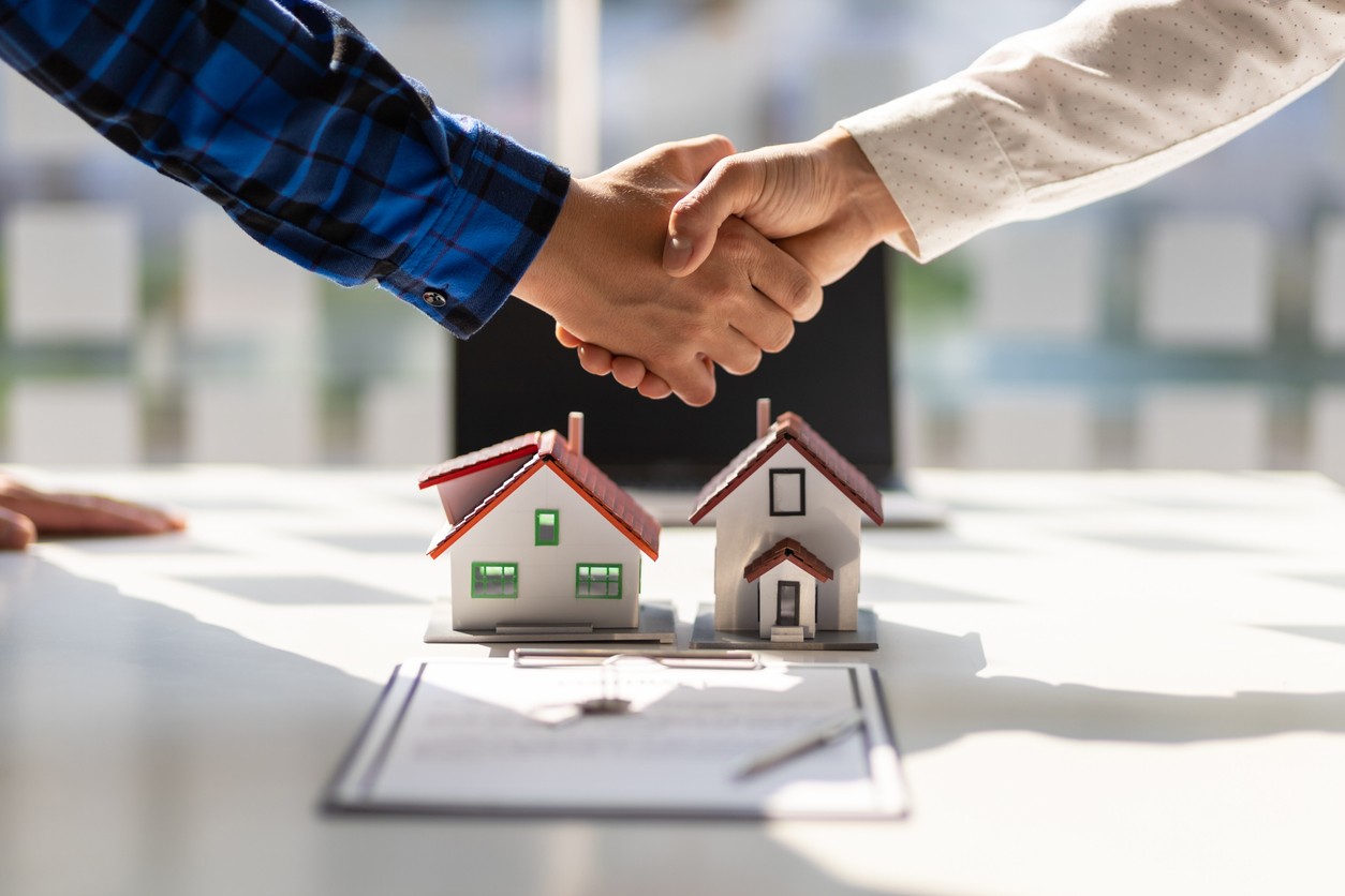 Real estate agents shake hands after the signing of the contract agreement