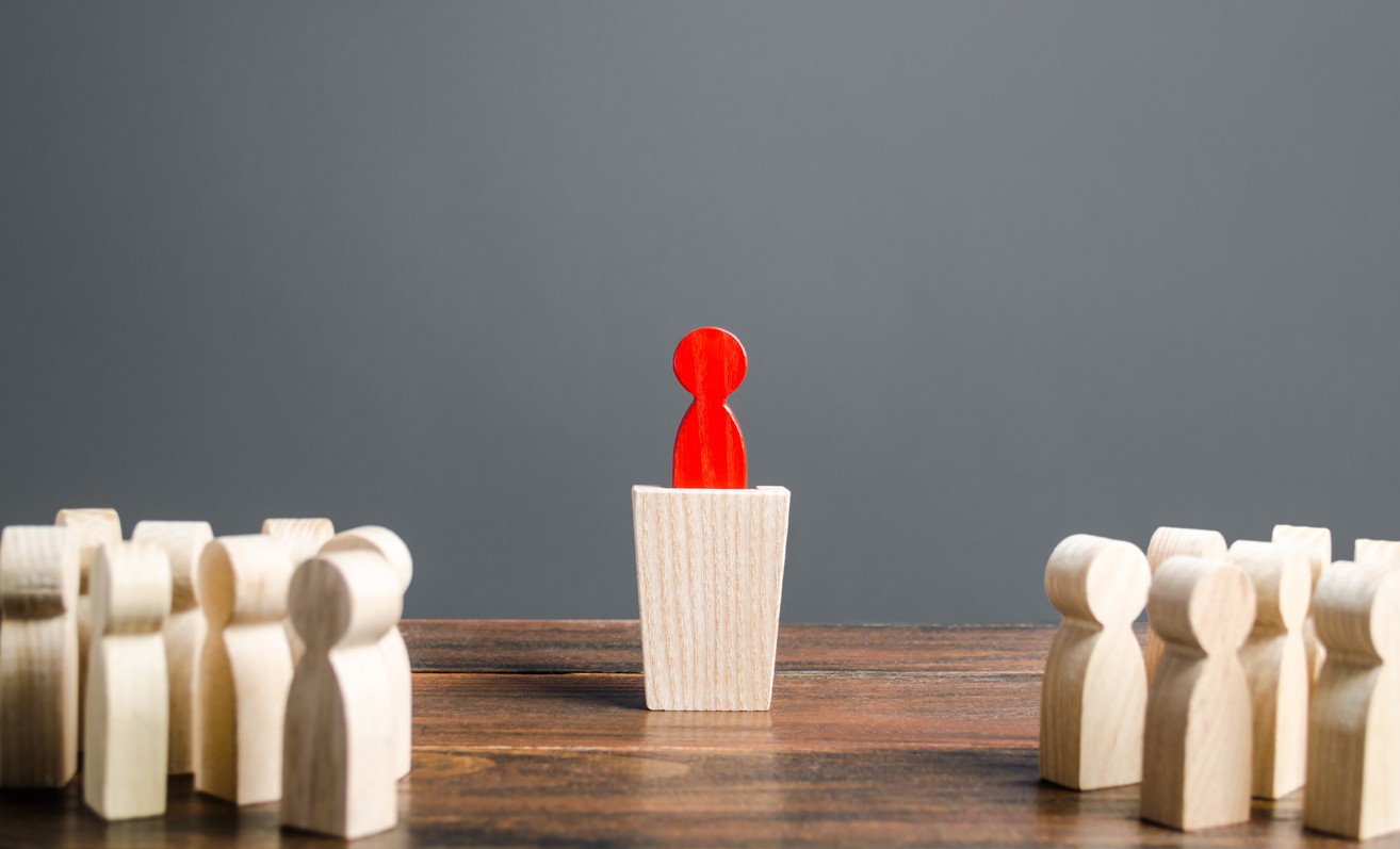 block shaped human with one block colored red in the middle on top of a rectangular block